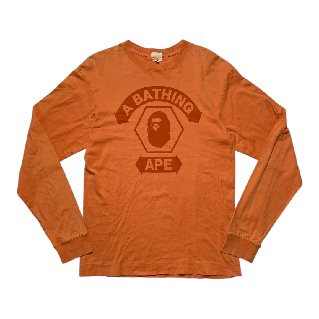 Orange long-sleeve shirt with 'A Bathing Ape' logo on a white background