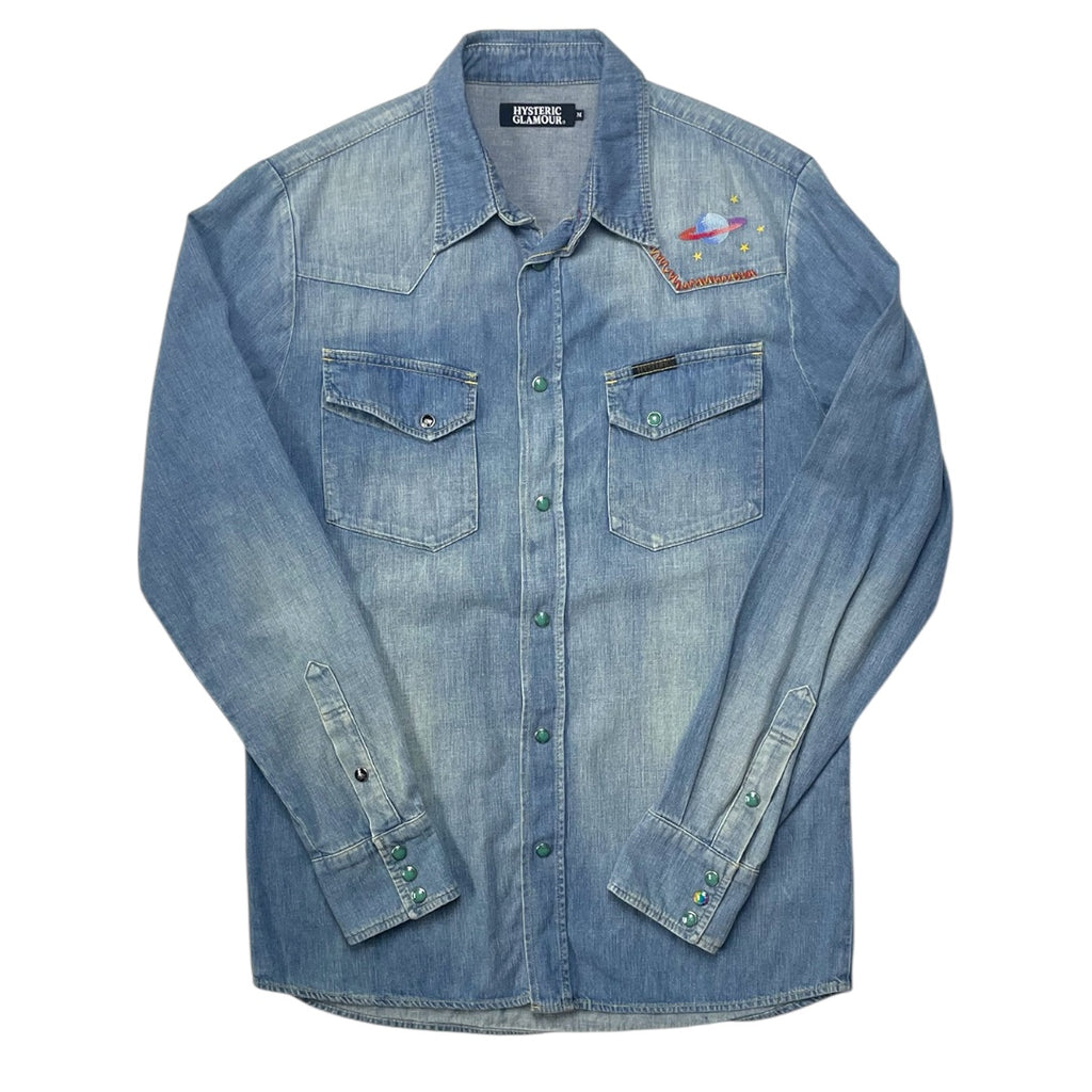 Blue denim shirt with embroidered designs on a white background